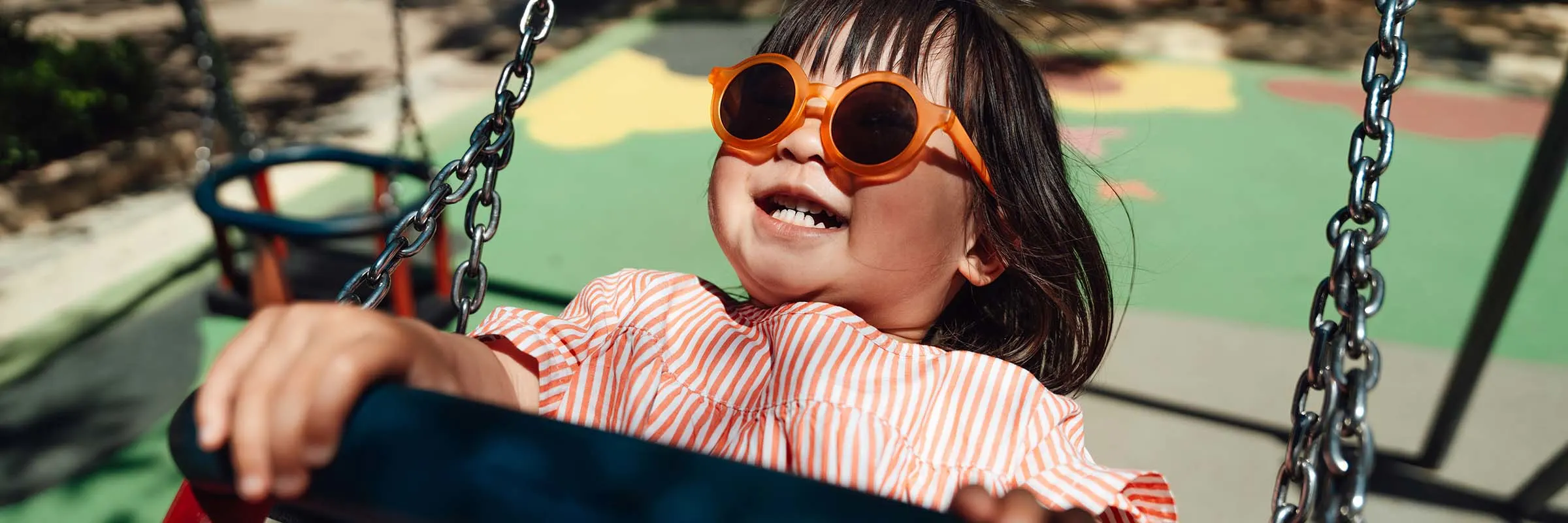 Girl smiling while swinging on a playset