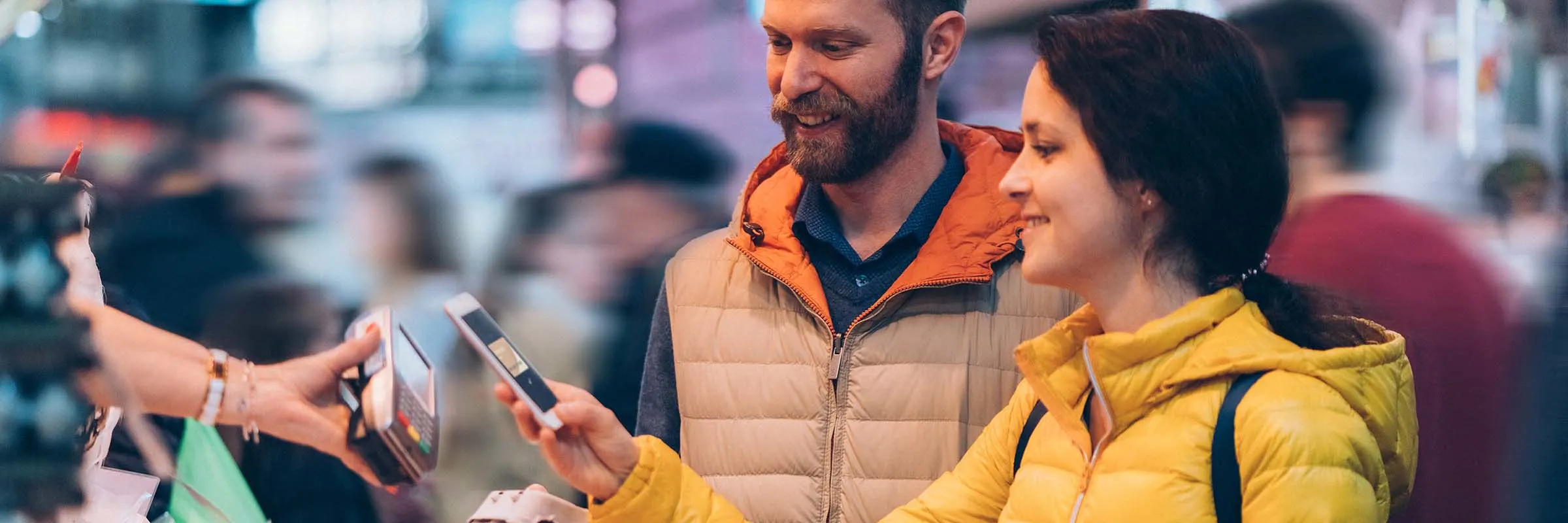 Couple using the digital wallet on their phone to pay for eggs at the farmer&rsquo;s market