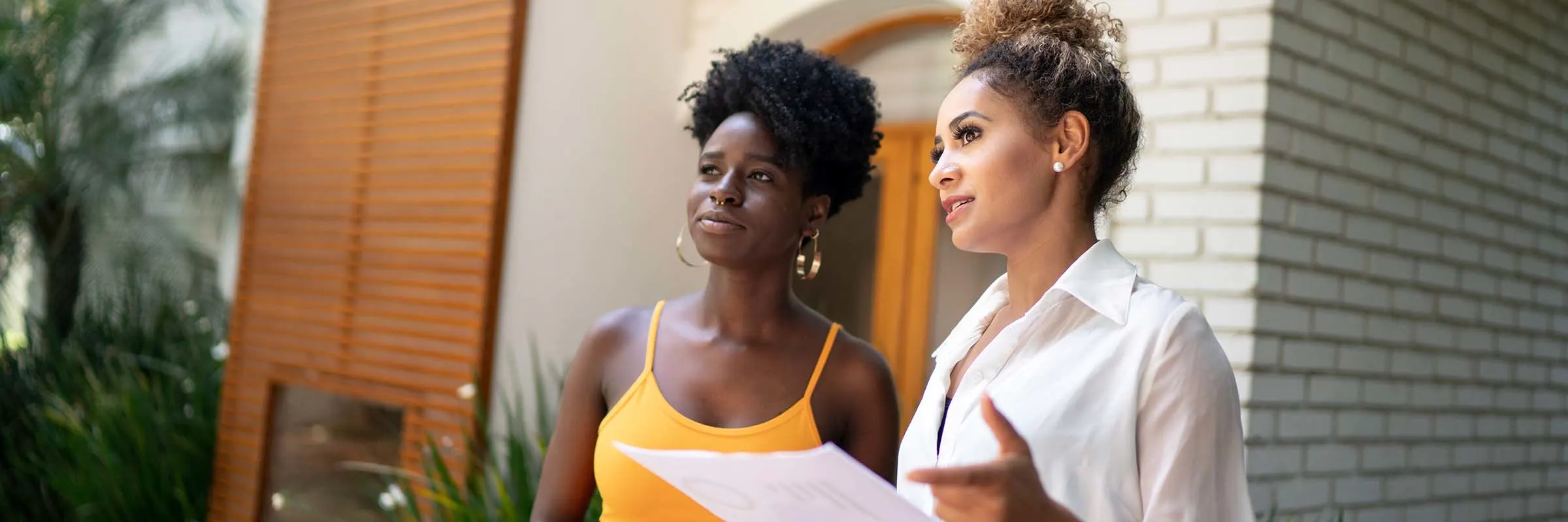 A real estate agent gives a young woman a tour of a home.