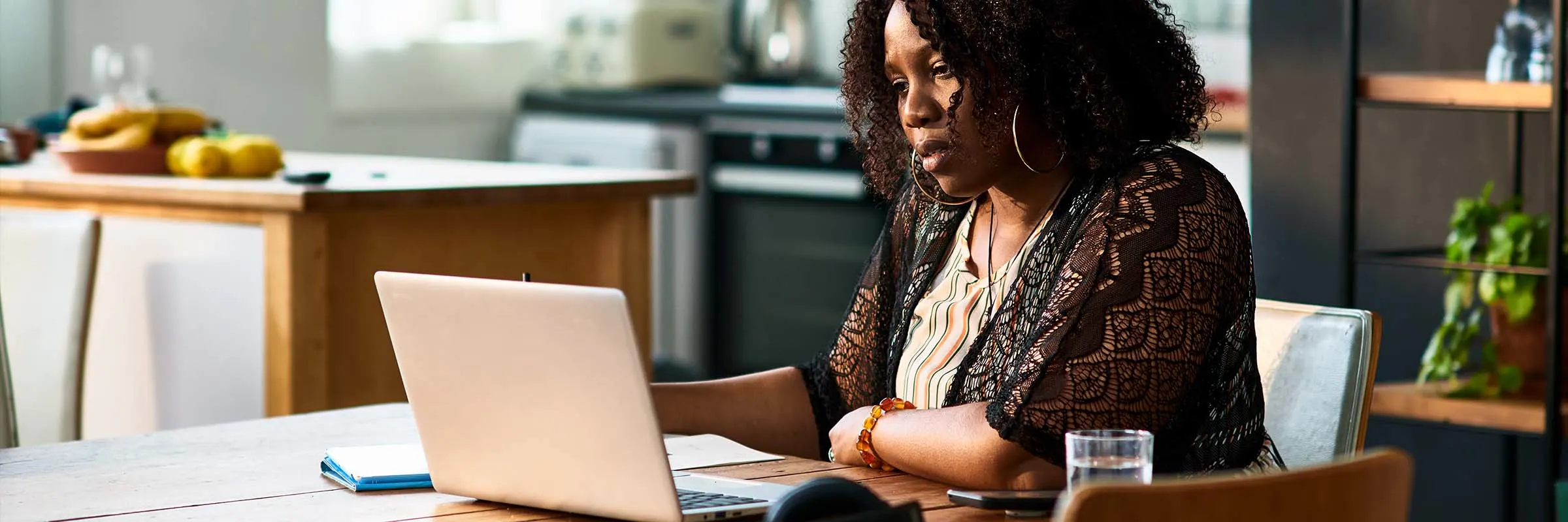 Concerned woman looking at her laptop in her dining room