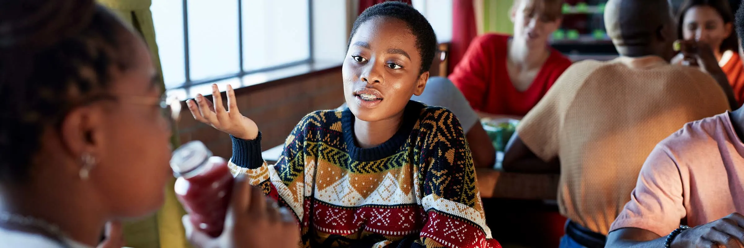 A young woman talks to her friend during a lunch break