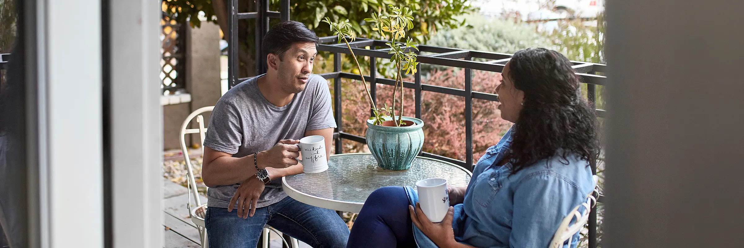 A young couple enjoys a private moment in the morning for coffee and conversation on the patio.