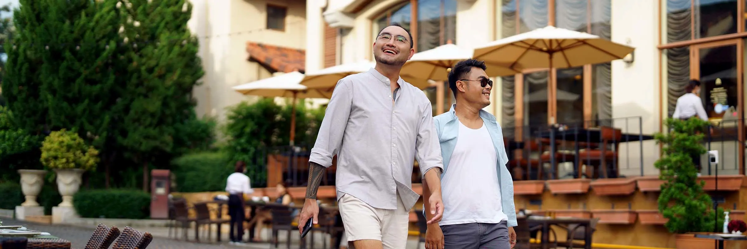 Two men happily walk through a vacation town