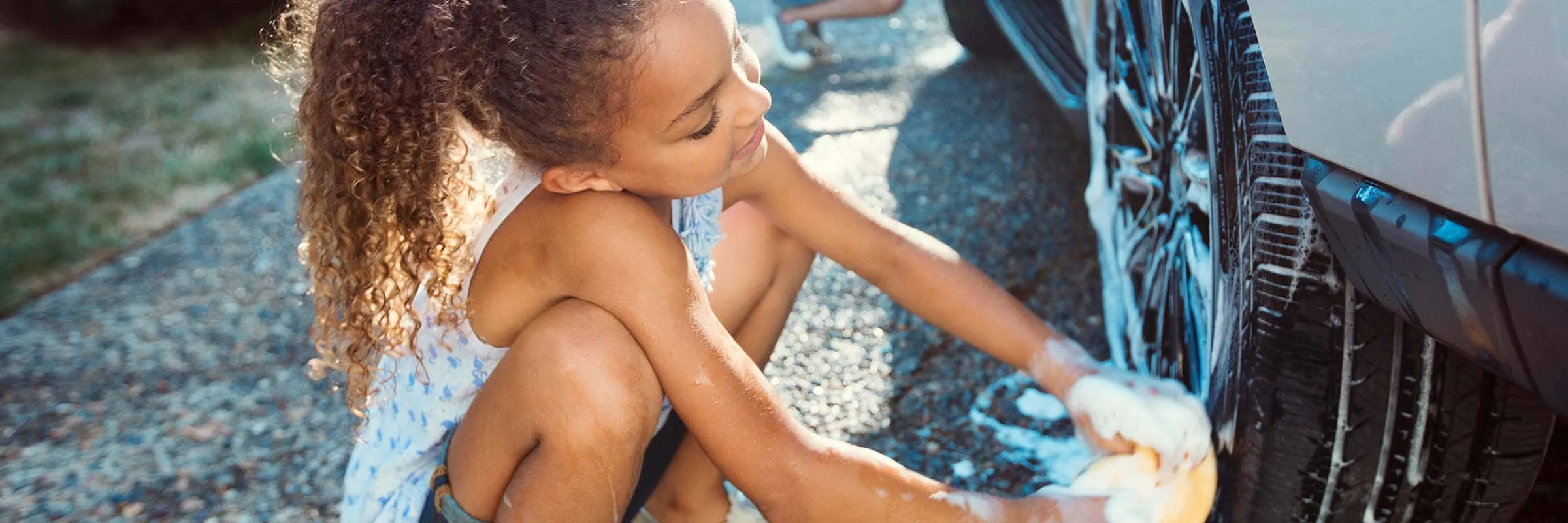 Two children washing a car.