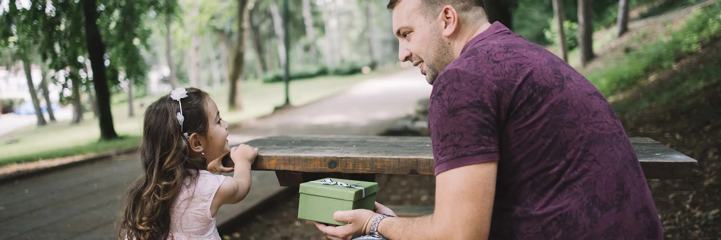 Dad and daughter have a conversation at a picnic table.