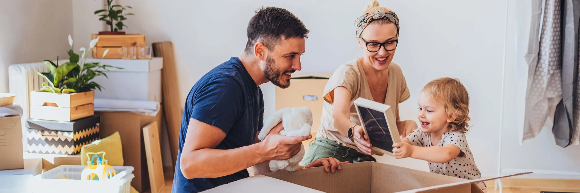 A family with a child unpacking boxes in a new home. 