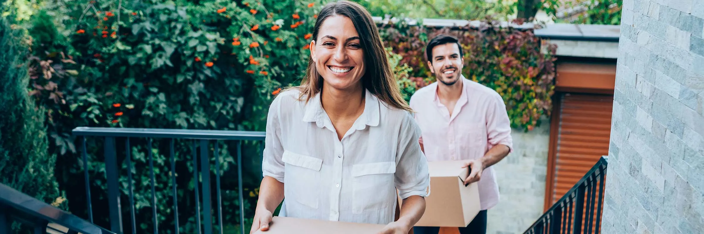 Couple walking up stairs carrying boxes