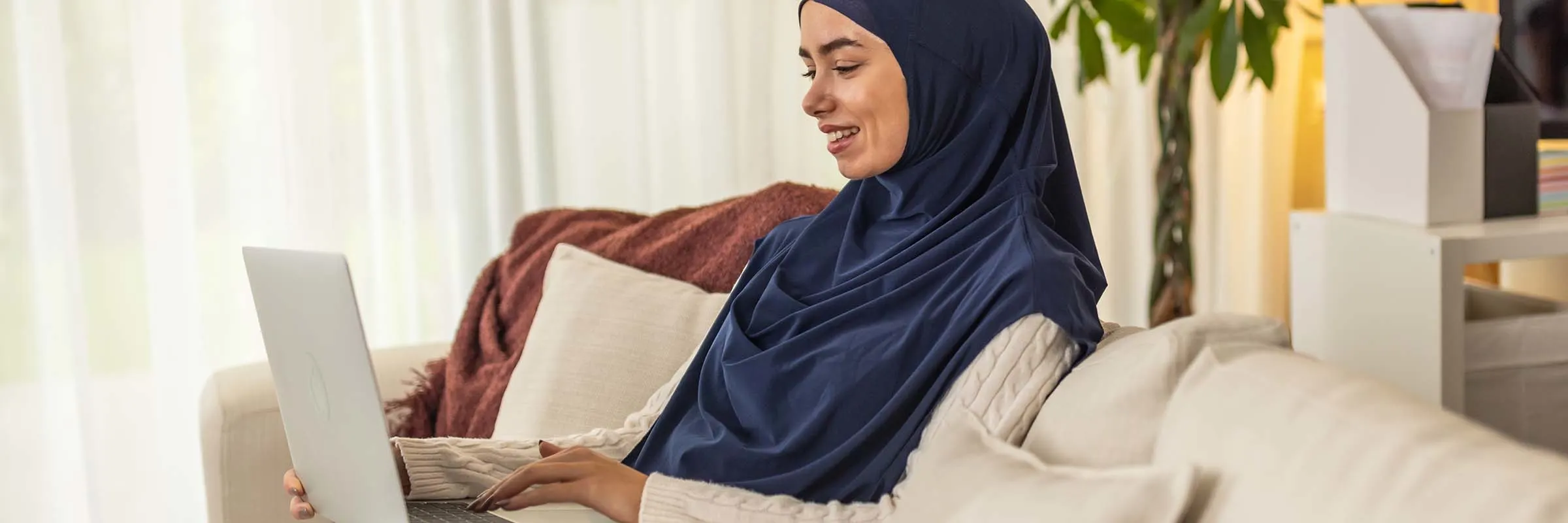 Image of a woman working on her laptop from her couch