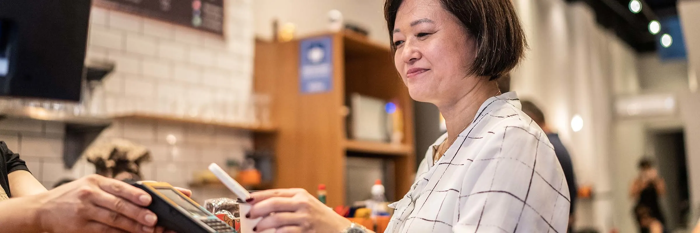 Woman paying with QR code in a shop.