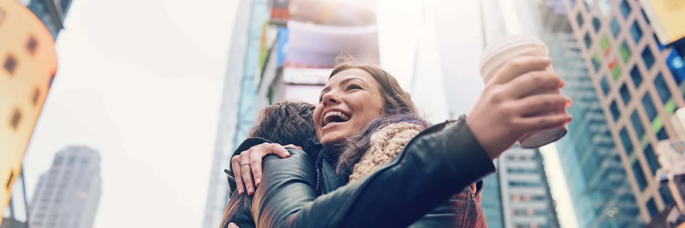 Two women embrace, happily, in New York City.