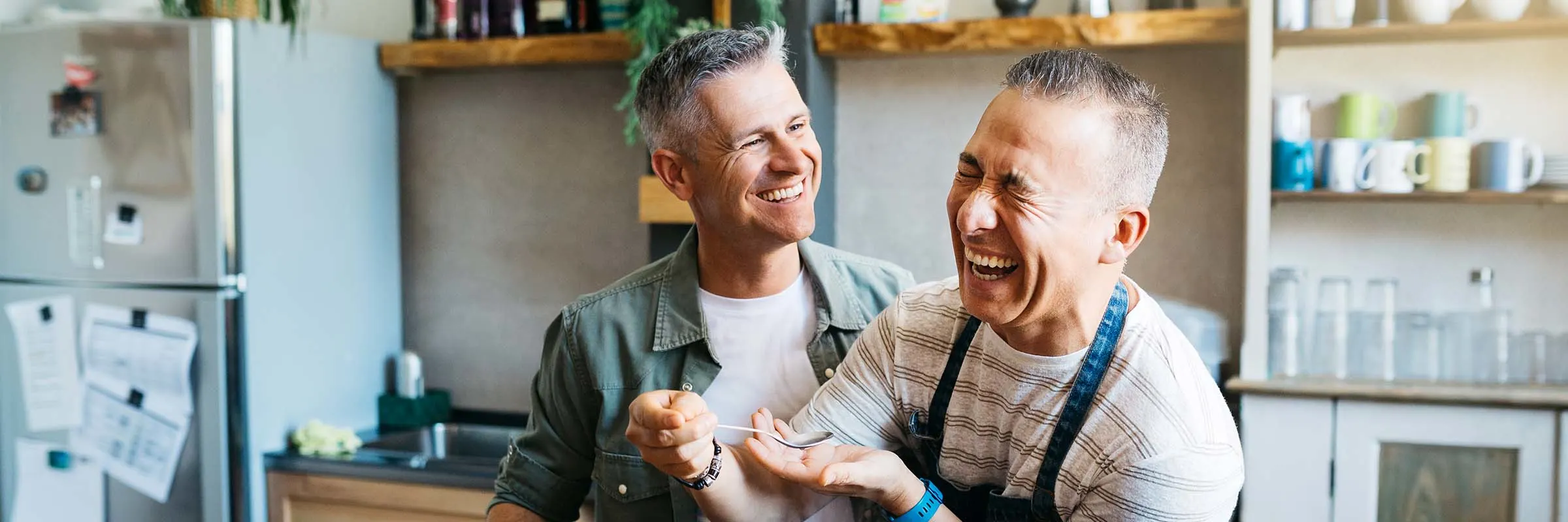 Middle-aged couple laughing and cooking in the kitchen