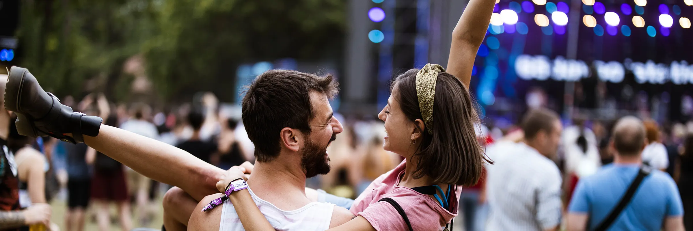 A couple dancing at an outdoor concert venue.
