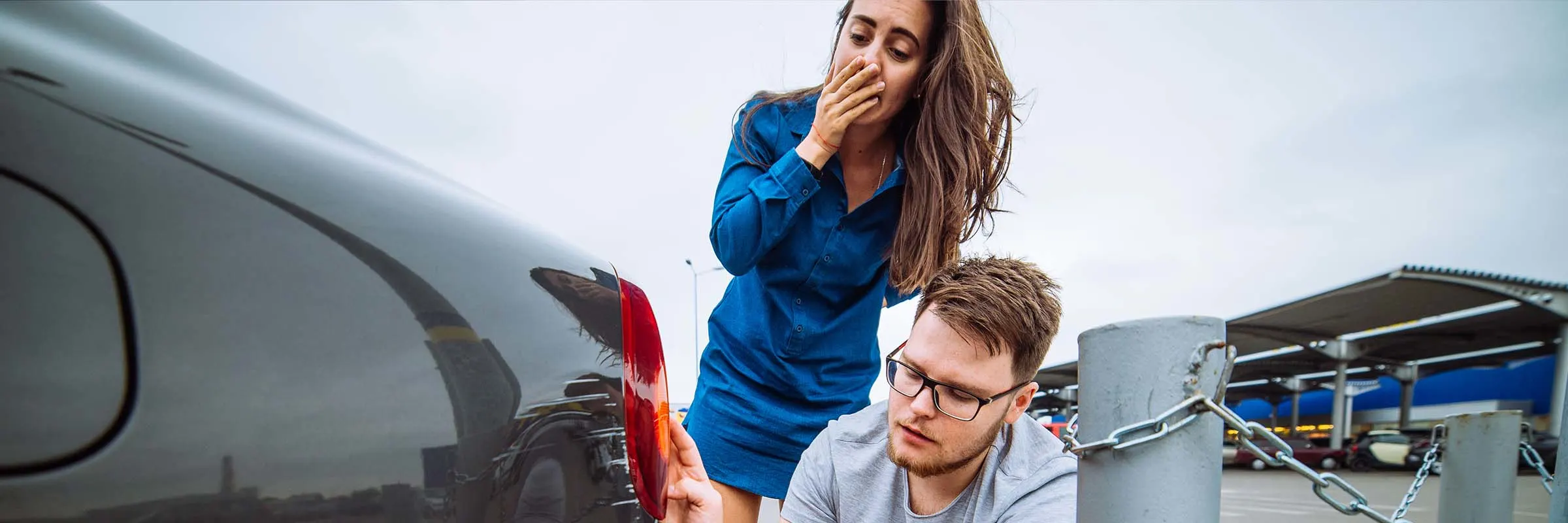 A woman in disbelief after seeing the scratches on her car from side swiping a pole.