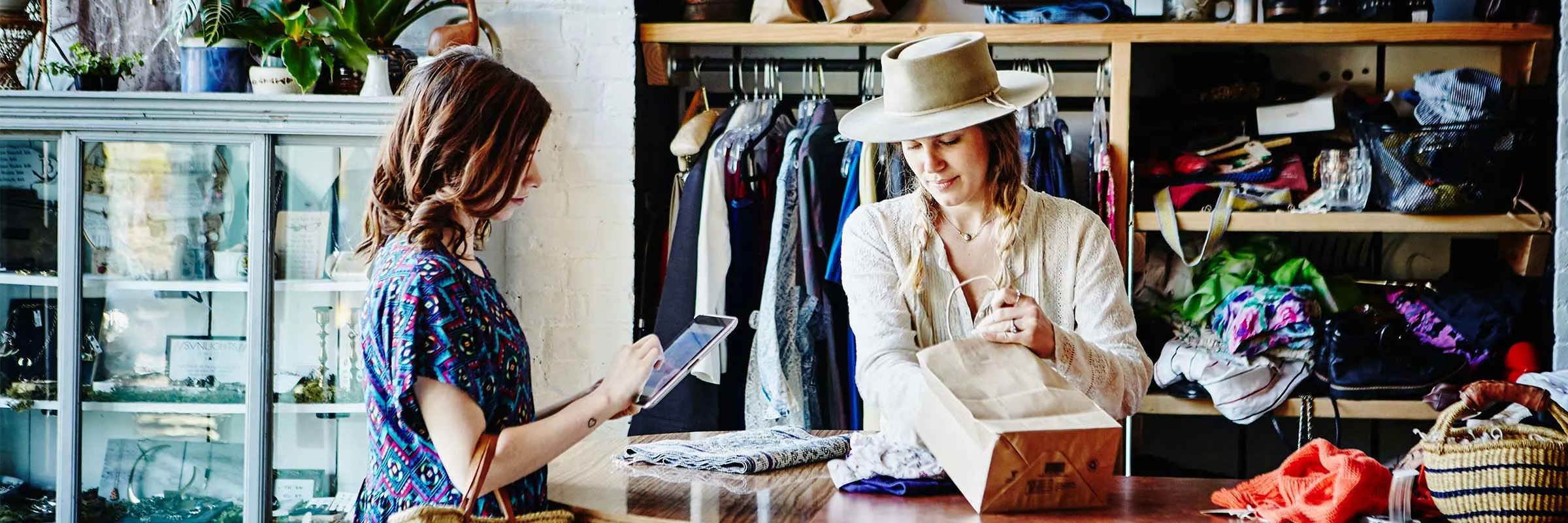 Woman paying for her recent retail purchase at a leather goods store with her digital wallet.