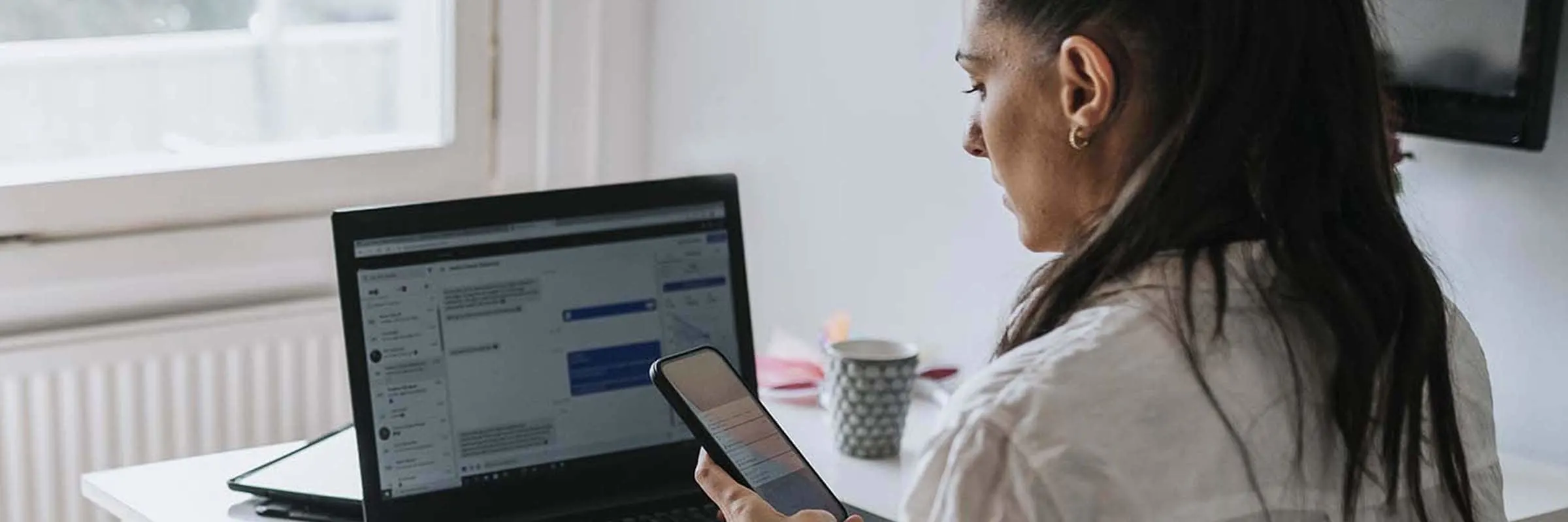 Woman working from home and looking at her phone