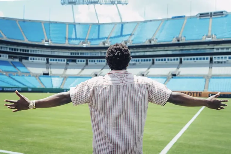 Sam on BoA field taking in the view of the stadium on a sunny day