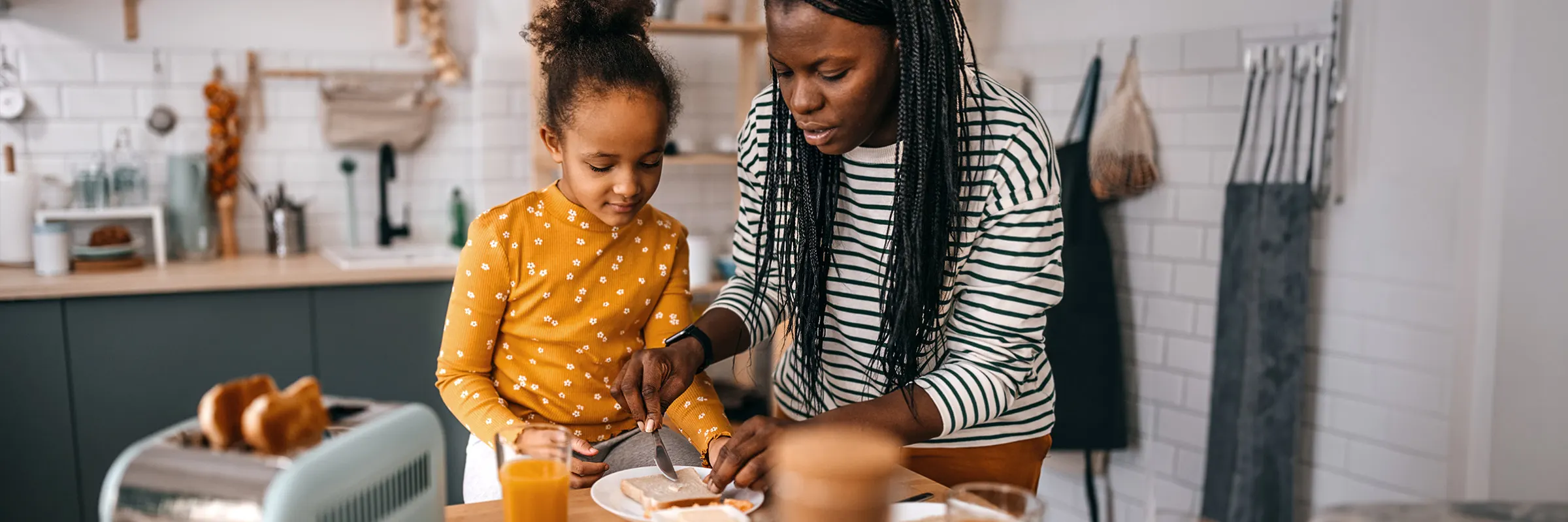 A mother and daughter prepare breakfast in the kitchen.

