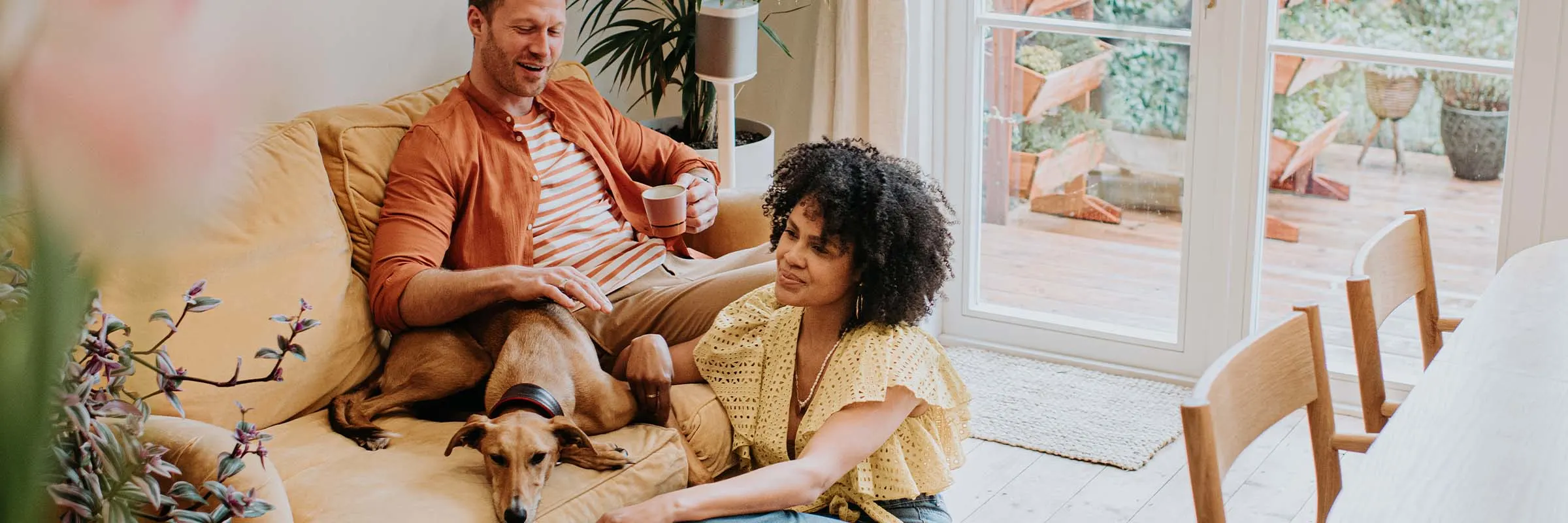 oung couple relaxing in their living room on their yellow couch with their new dog