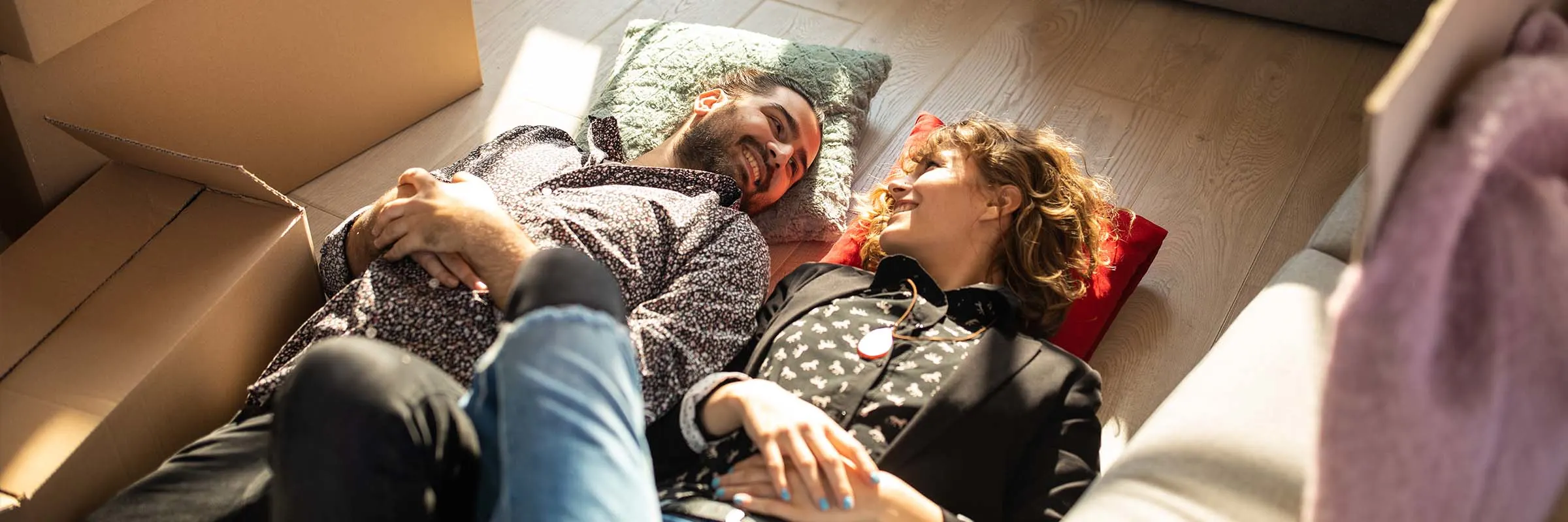 Young couple in love lying on the floor enjoying their new home together