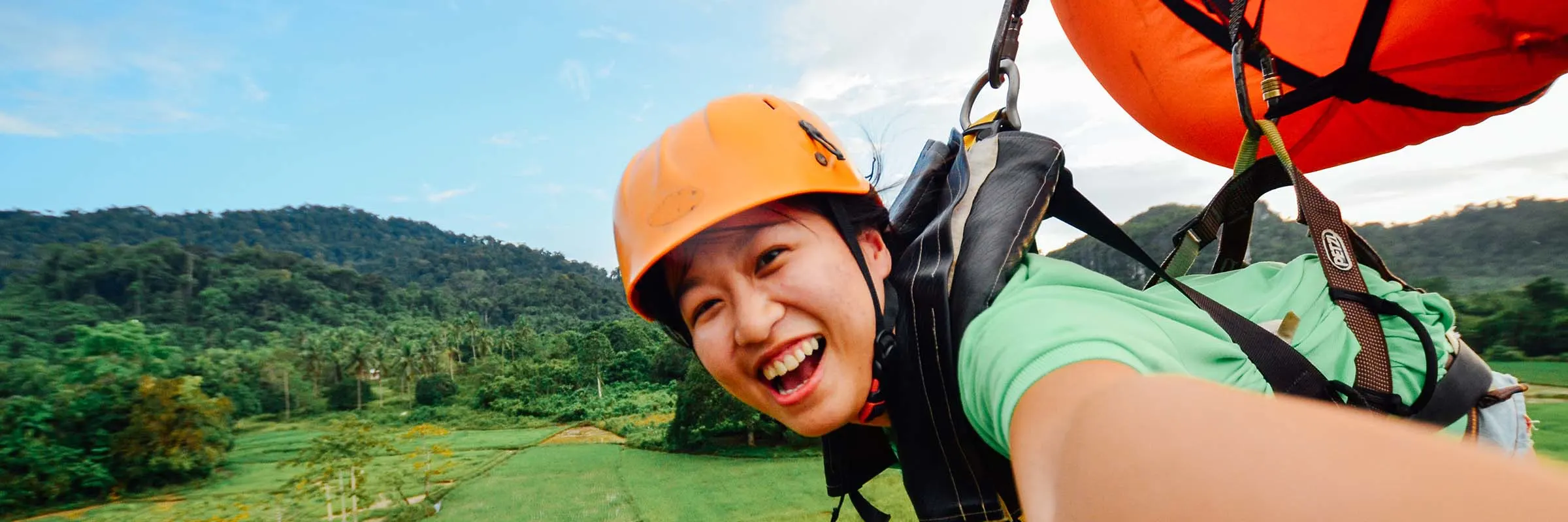 Image of a woman parasailing over a field