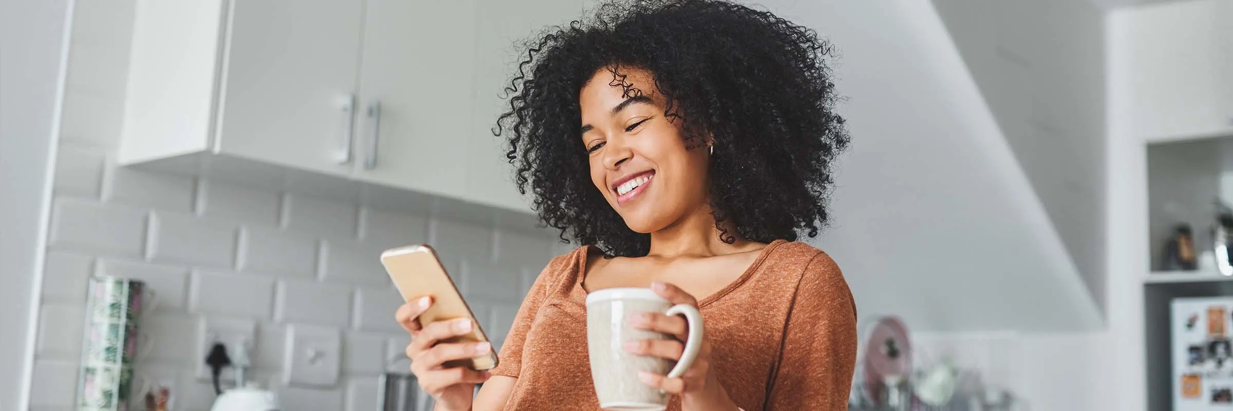 Woman smiling looking at her phone.