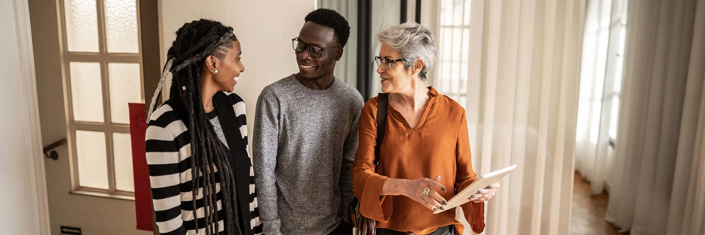 Real estate agent shows a property to a young couple.