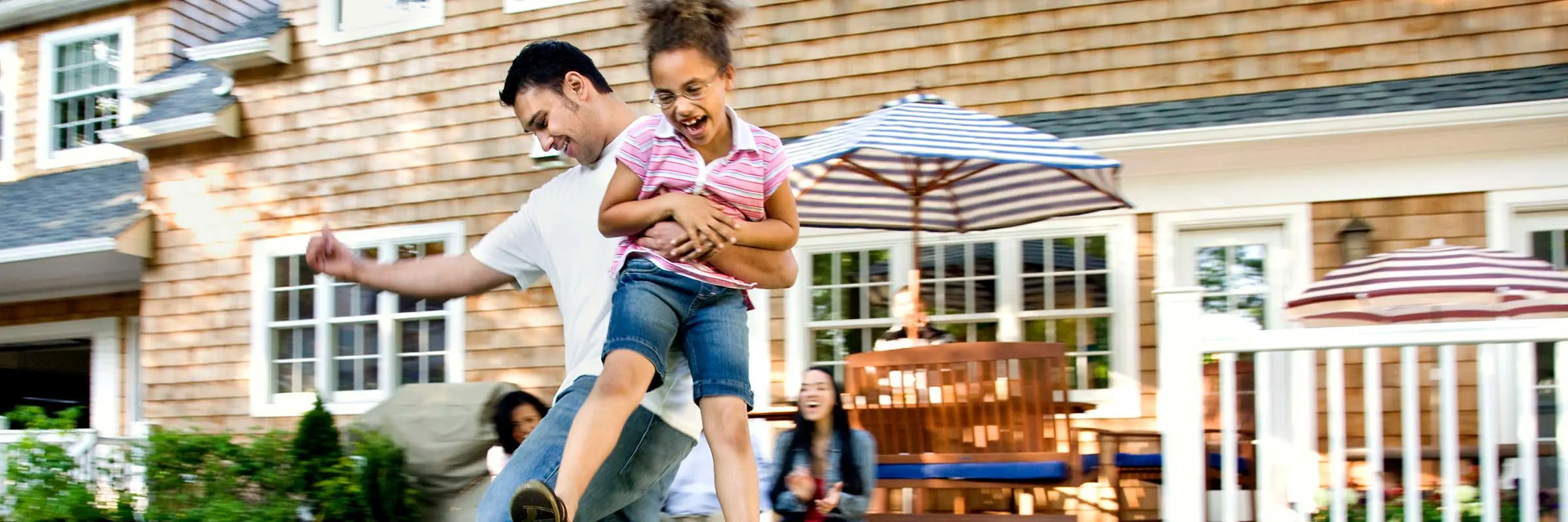 Father and daughter playing soccer together in a backyard