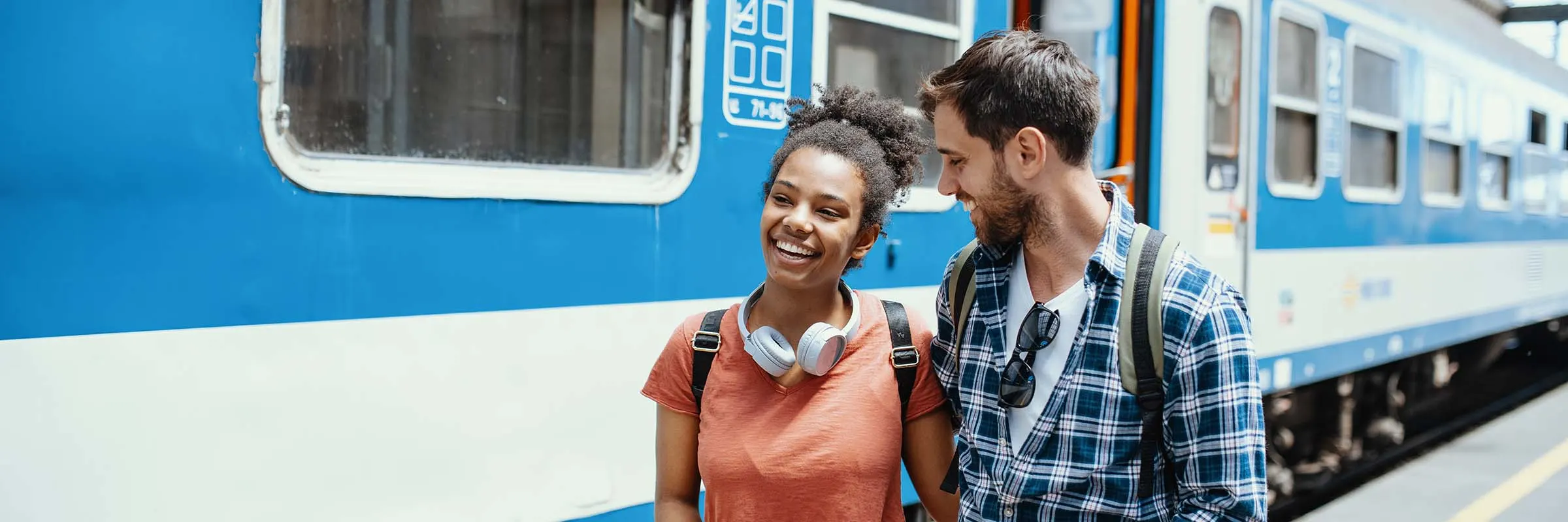  Young woman and man walking by a train while traveling