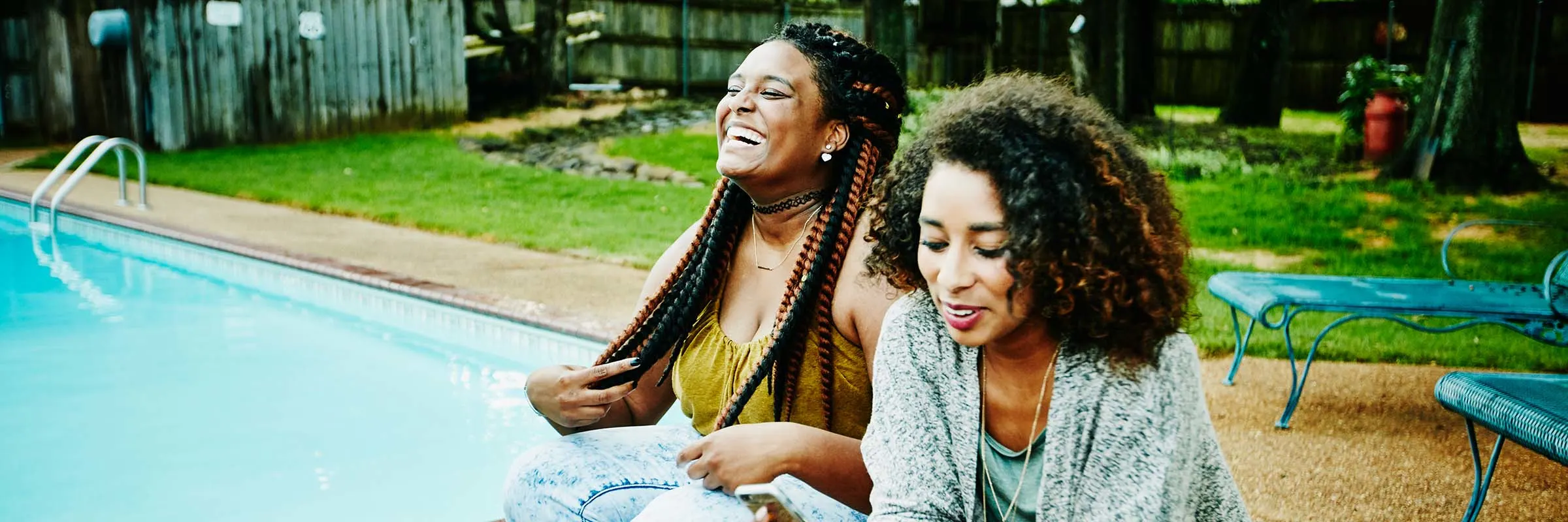 Woman laughing, hanging out with friends by the pool.