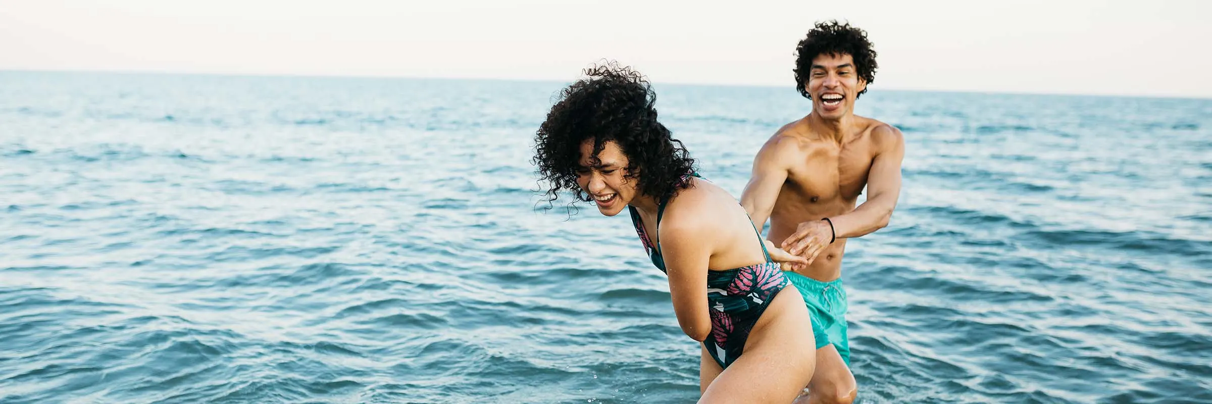 Image of a couple laughing and playing in the ocean water