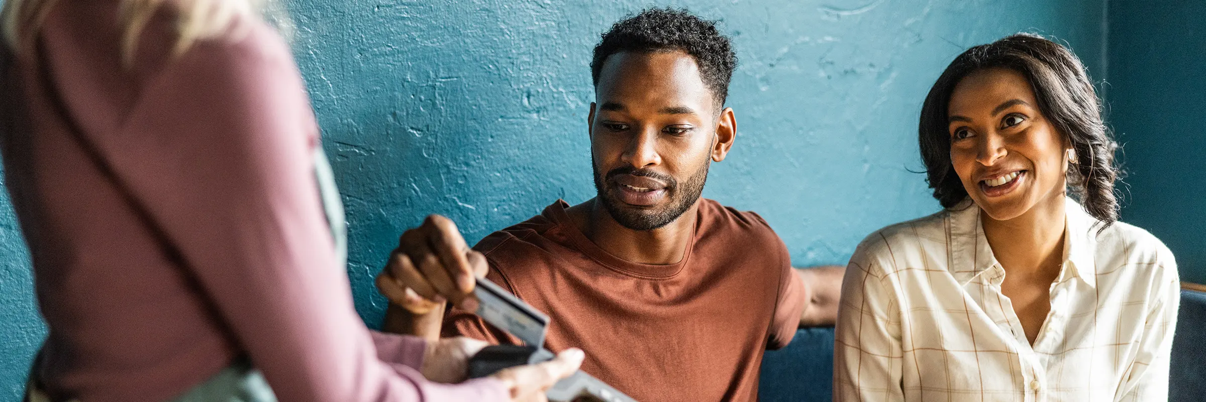 Man using his card to tap to pay at café.  