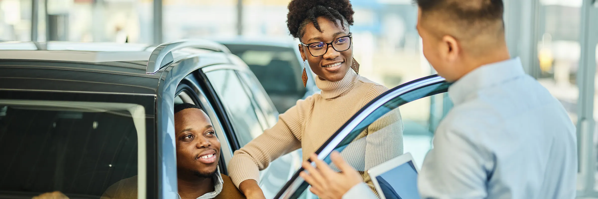 Couple inquiring about a car purchase with a salesman.