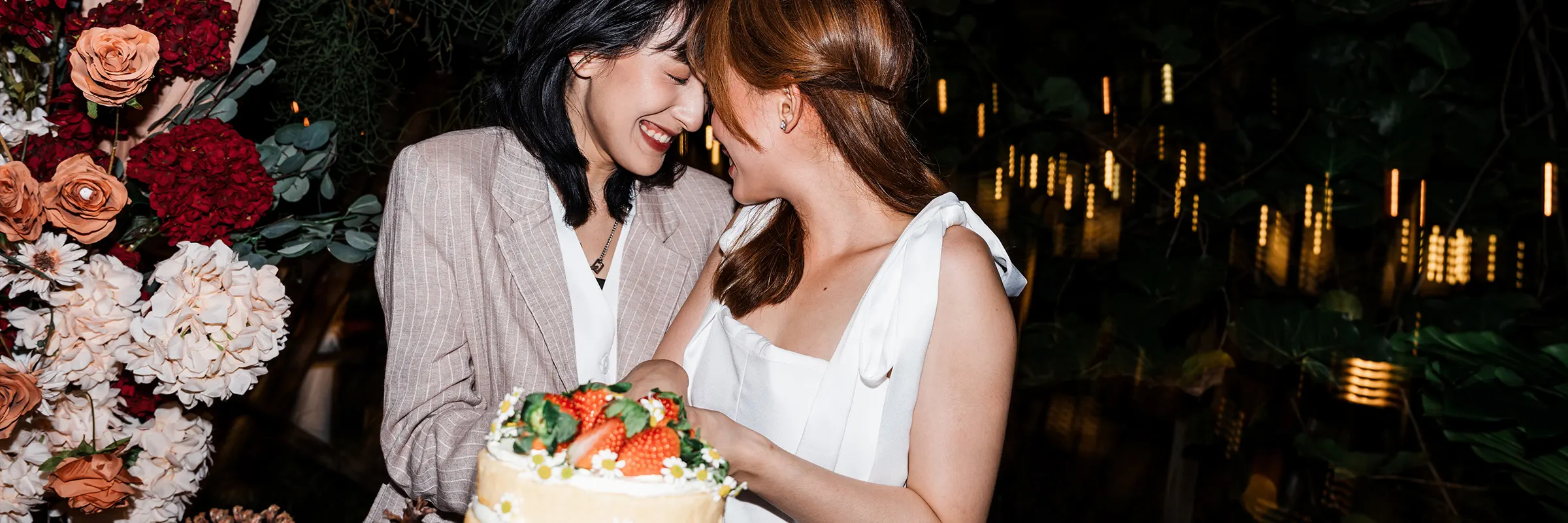 Newly married couple smiling and cutting their cake. 