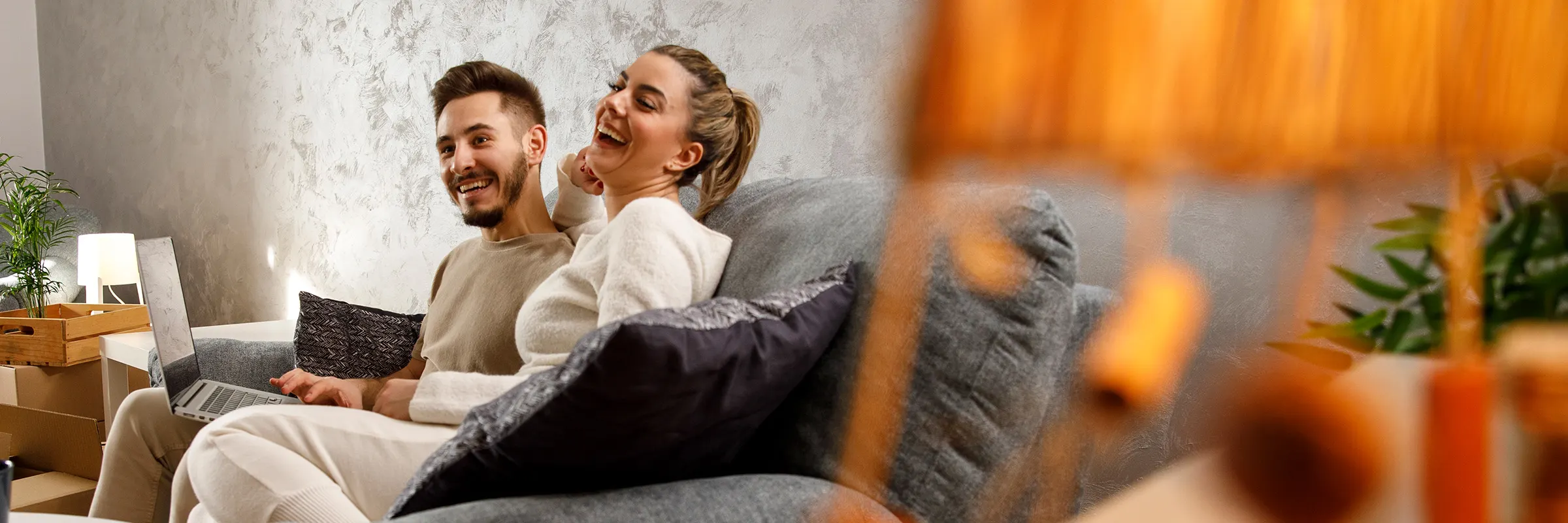 A couple relaxes and laughs on the couch.