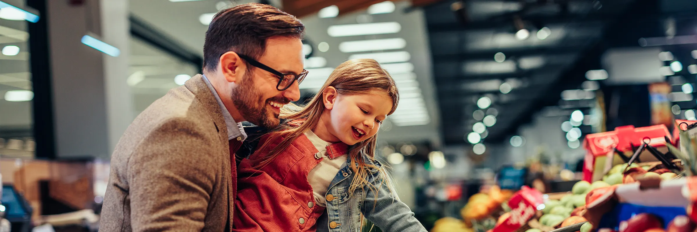 A parent and child shop for produce at the grocery store