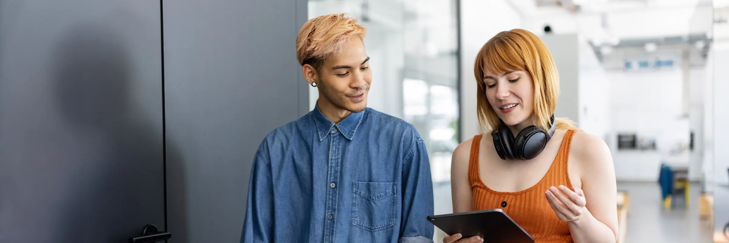 Two colleagues walk down the hallway while in discussion.
