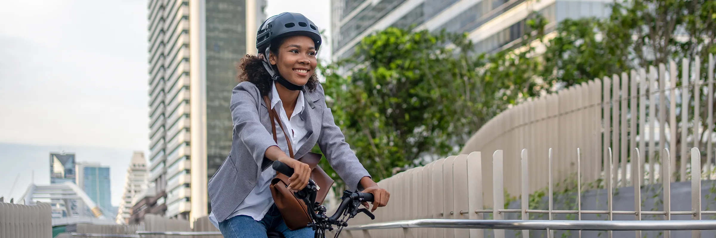 A woman rides her bike to work down an urban path.