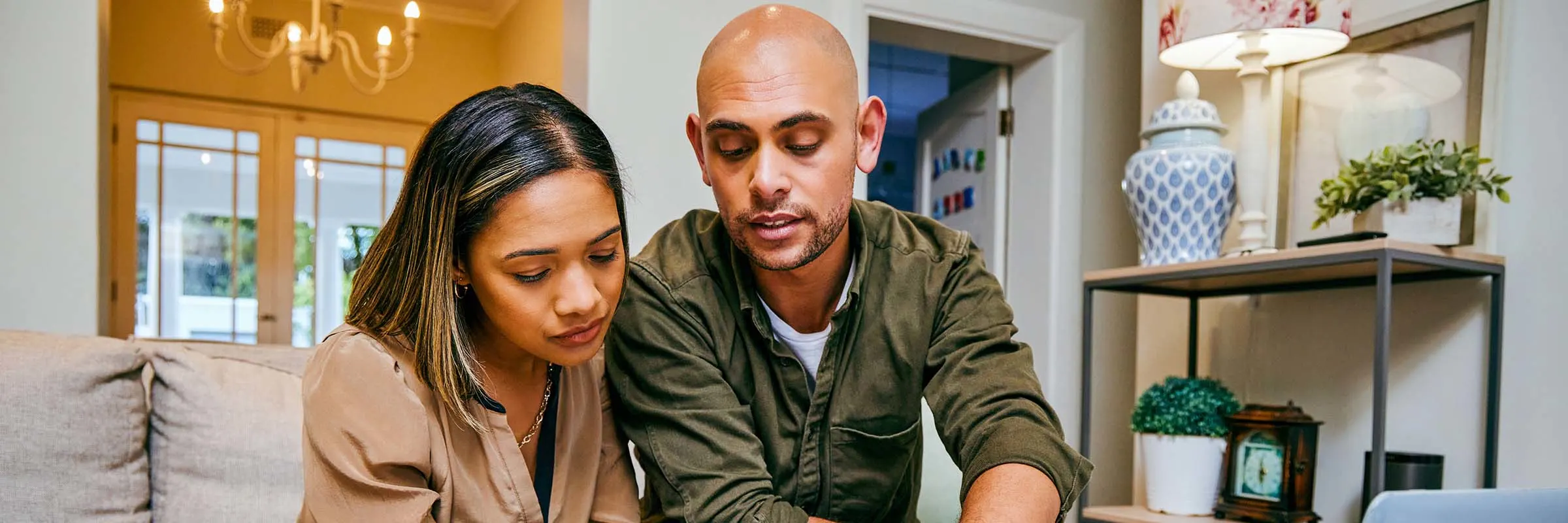 a young couple reviewing their finances while using their laptop&nbsp;