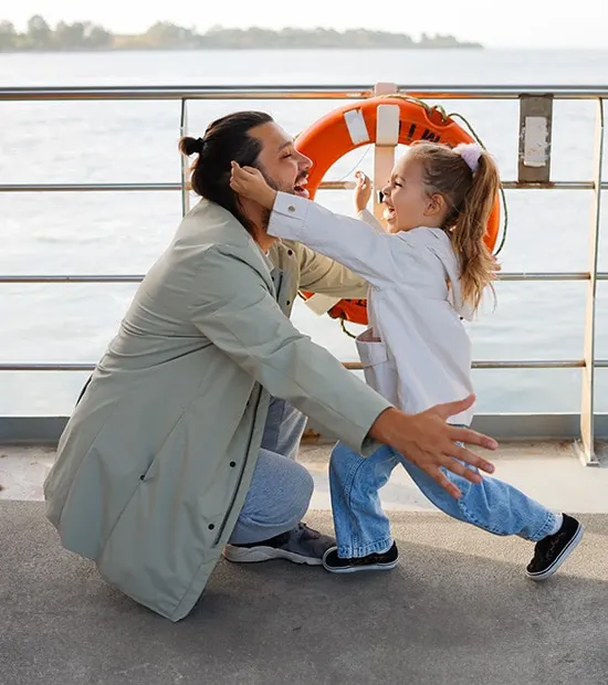 Father and daughter embracing on a cruise ship deck. 