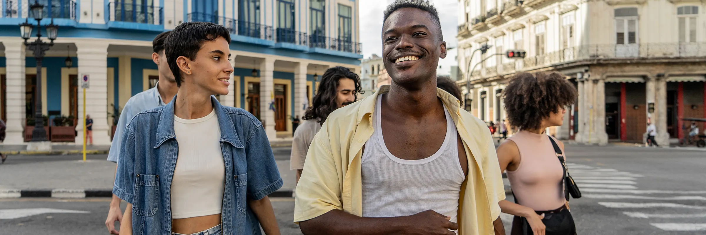 A group of young people on vacation happily walk through a city