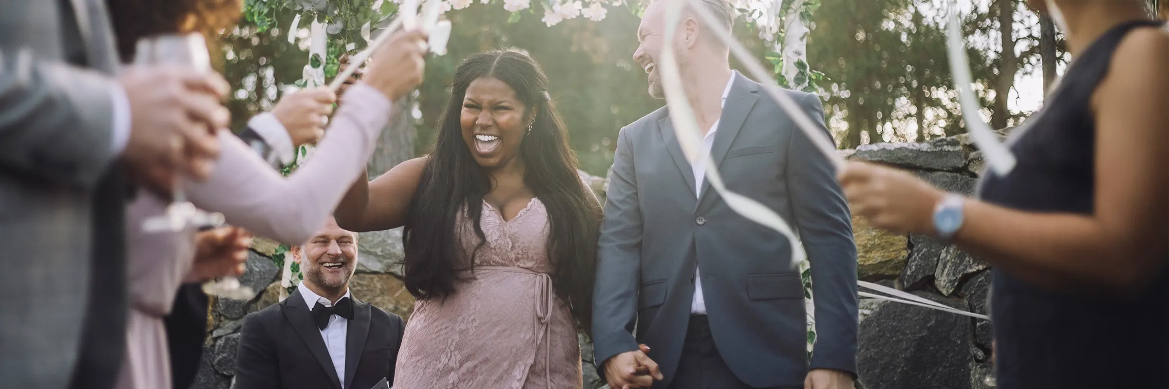 Newlywed bride holding hand of groom while walking amidst guests at wedding ceremony