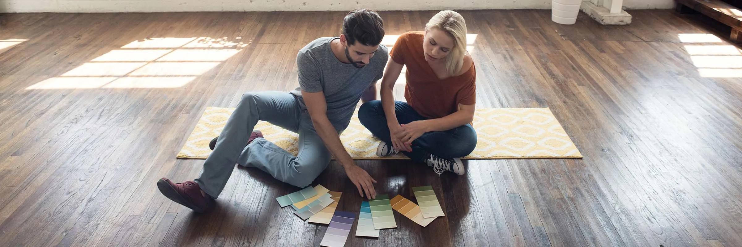 Young couple sitting on the floor looking at plans for their home