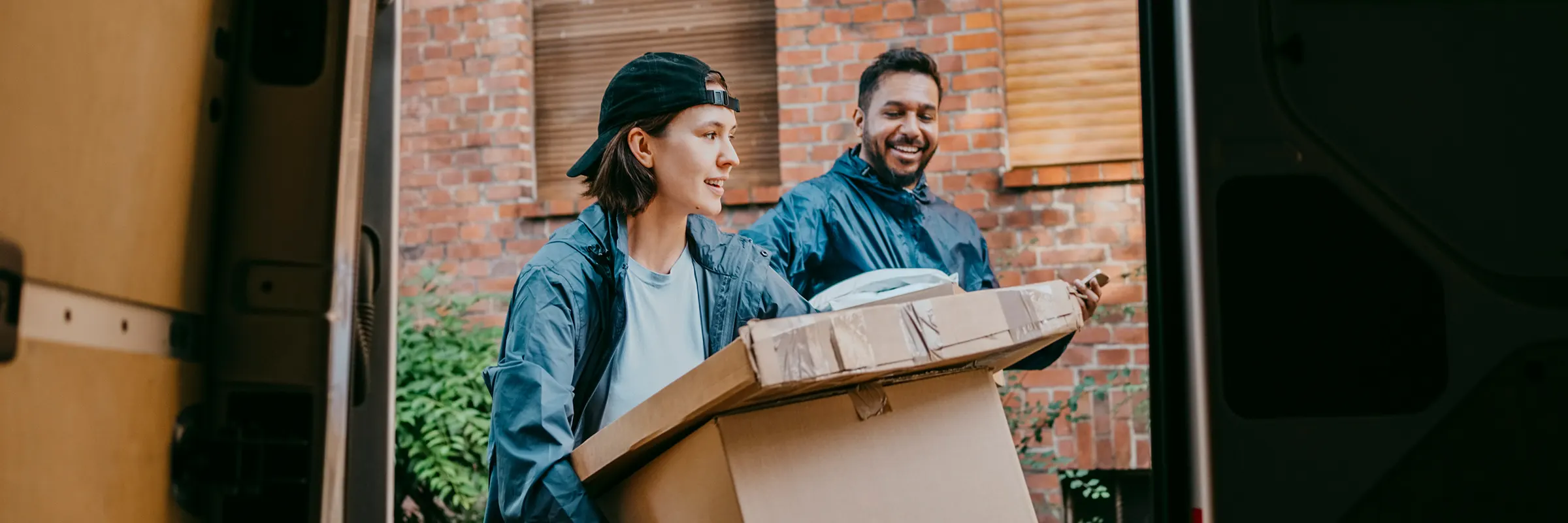  Two people unloading boxes from a truck. 