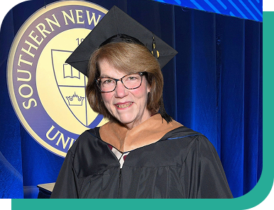Lynne smiles proudly in a cap and gown at her Southern New Hampshire University commencement