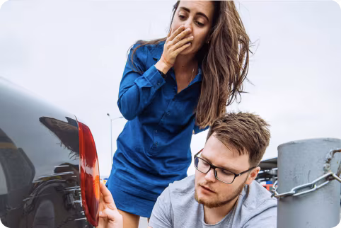 a woman and man looking at their car