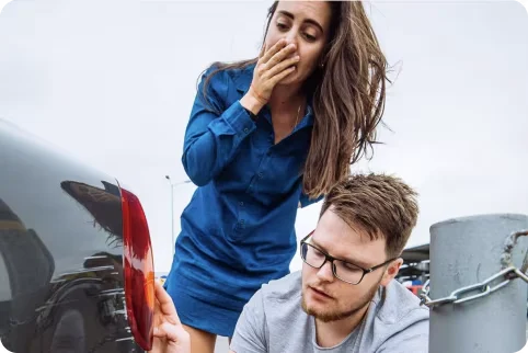 a woman and man looking at their car