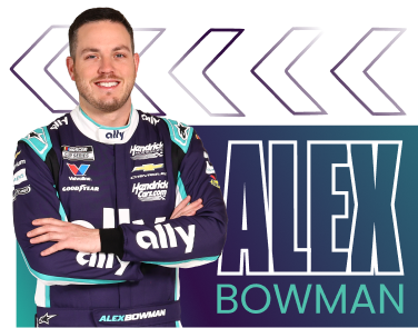Alex Bowman with arms crossed in his purple fire suit.