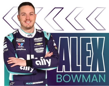 Alex Bowman with arms crossed in his purple fire suit.