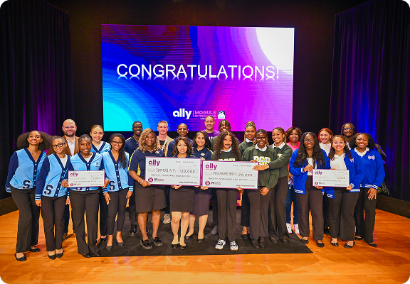 a group of smiling students and Ally employees displaying donations.