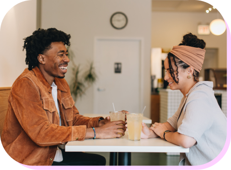 A smiling man and woman sitting in a restaurant.